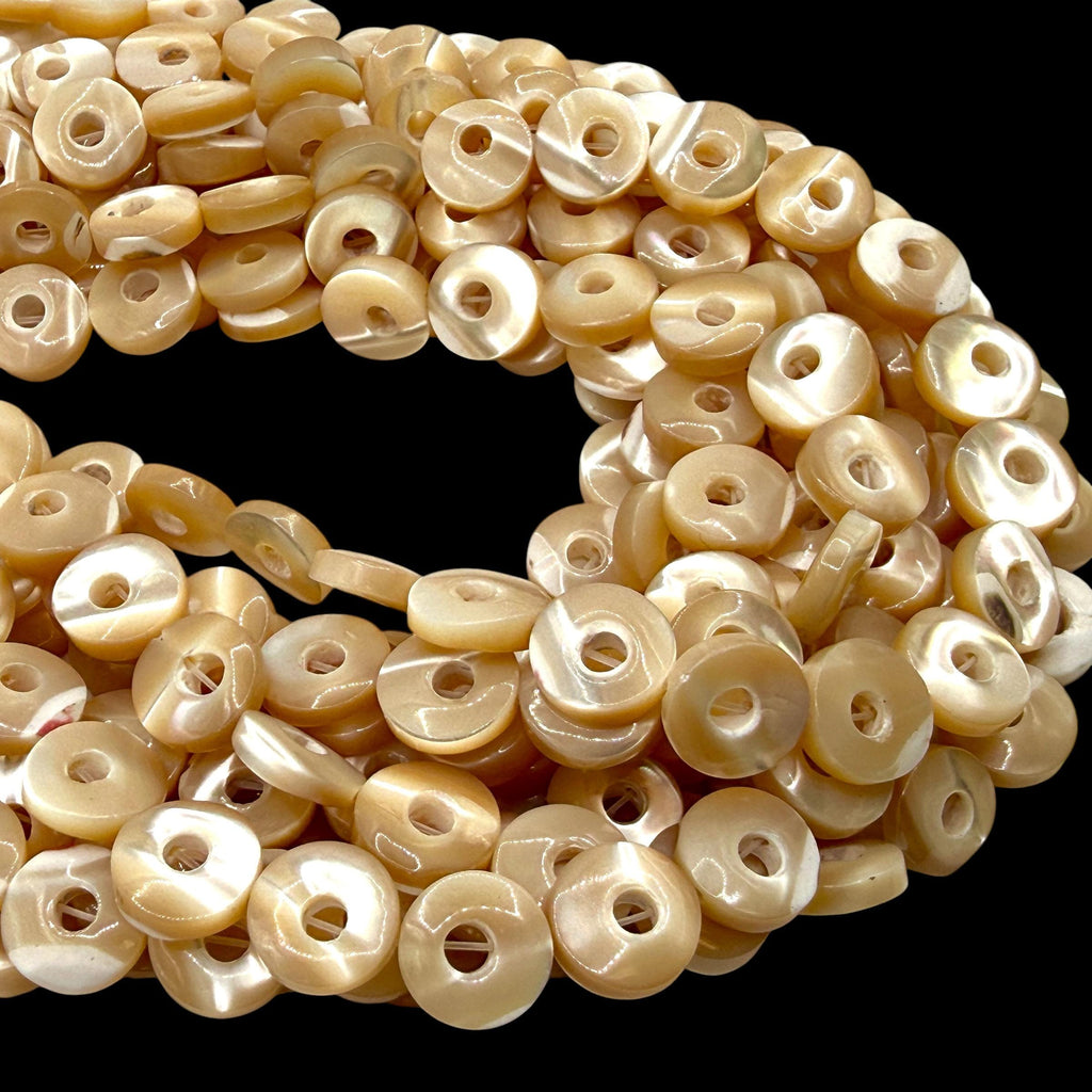 High luster troca shell donut beads in champagne golden color, 10mm round disc shape, full strand on black background