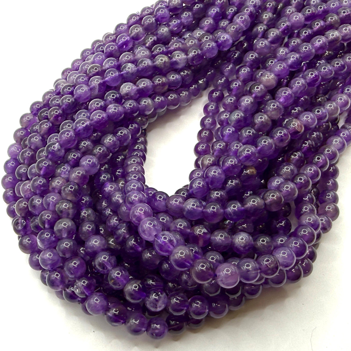 close up of natural amethyst beads showing color zoning, dark purple gemstone beads for jewelry design